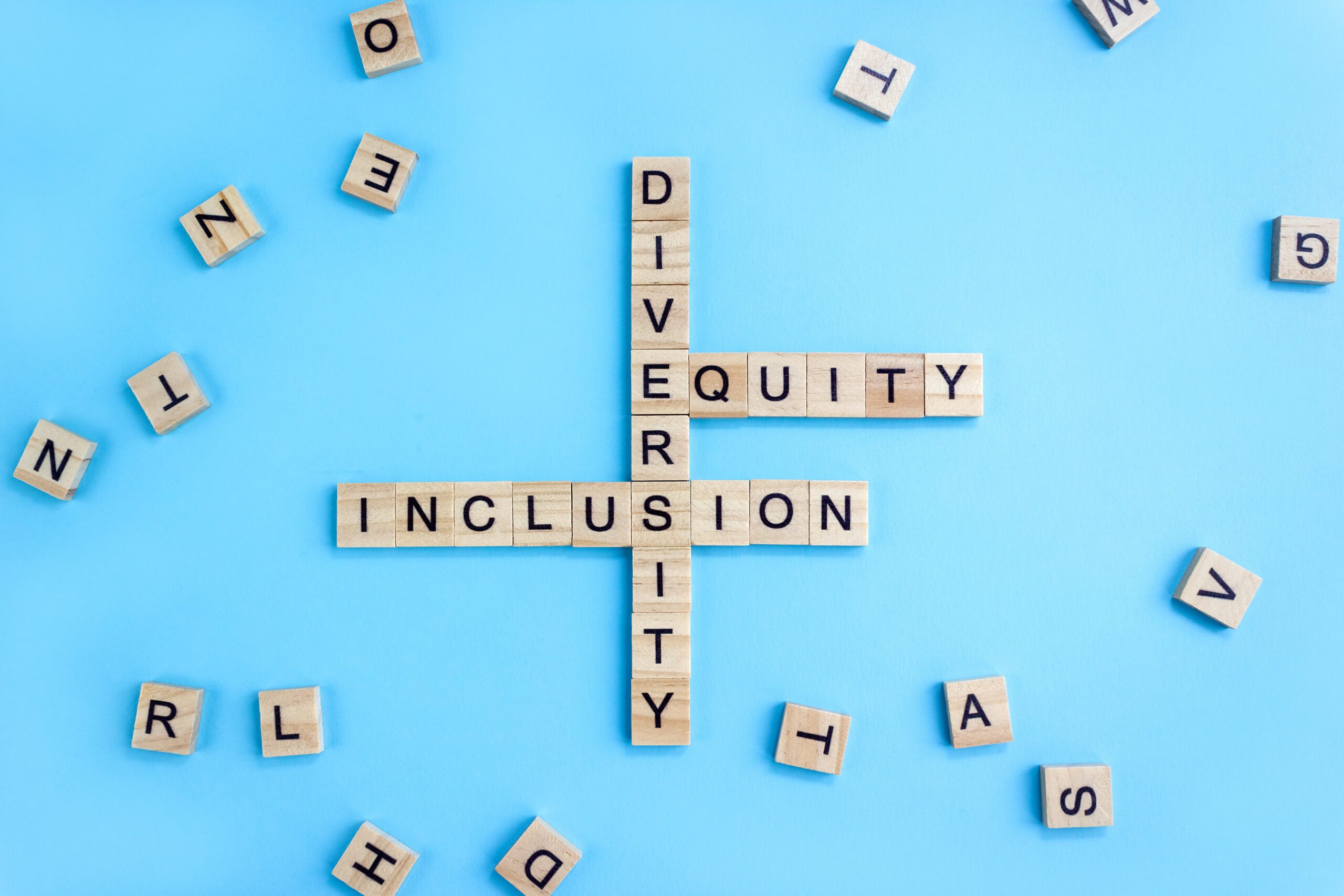 Word Diversity, Equty and Inclusion on wooden blocks on blue background. Business concept DEI