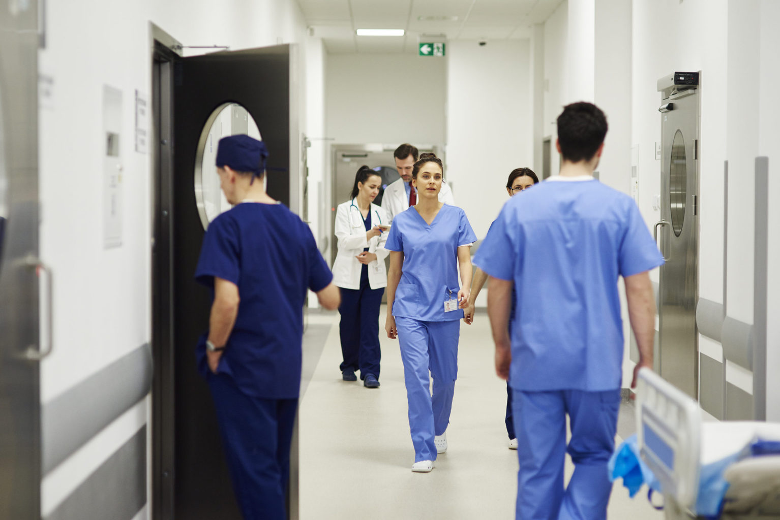 Doctors and nurses walking through corridor in hospital