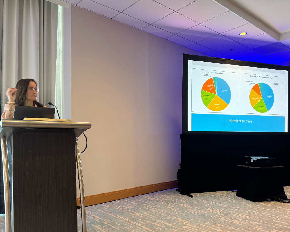 Photo of Dr. Carissa Tyo, UI Health, presenting her session with projected slides off to her left.